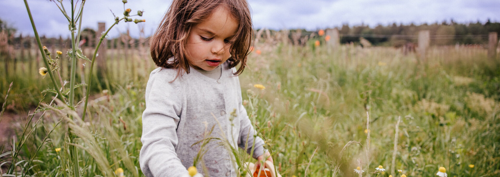 Mädchen steht in einer Blumenwiese