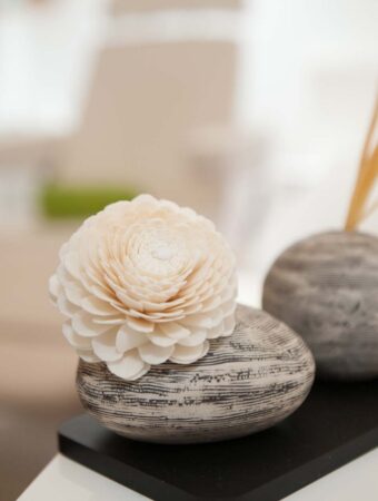 Eine weiße Blüte liegt auf einem grau marmorierten Stein.